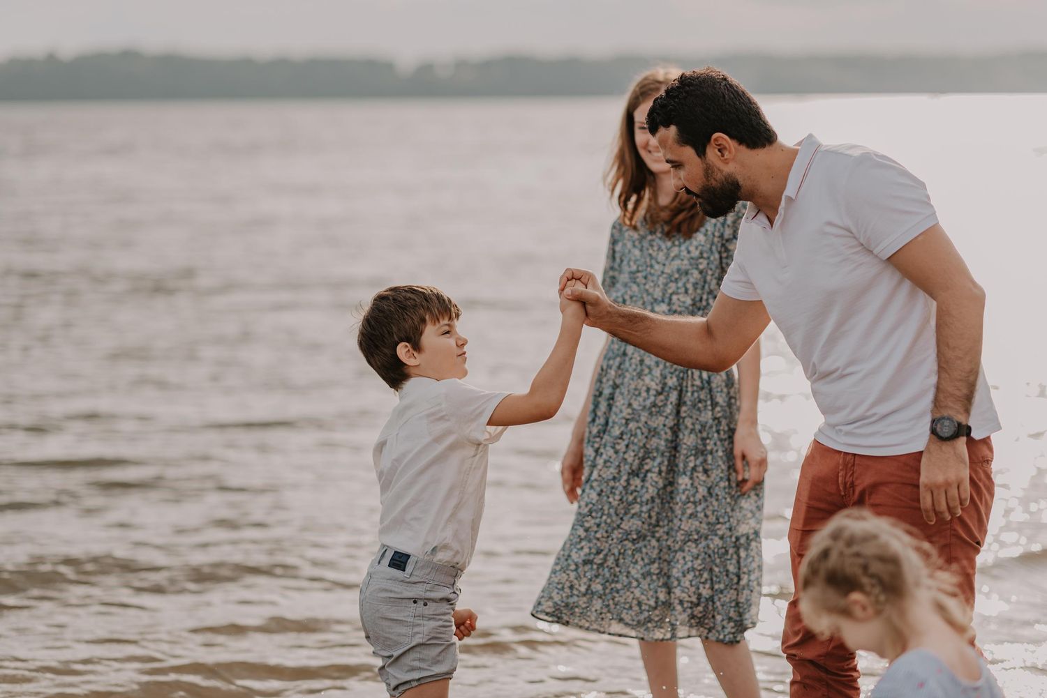 Family sharing a tender moment together on the beach at sunset.