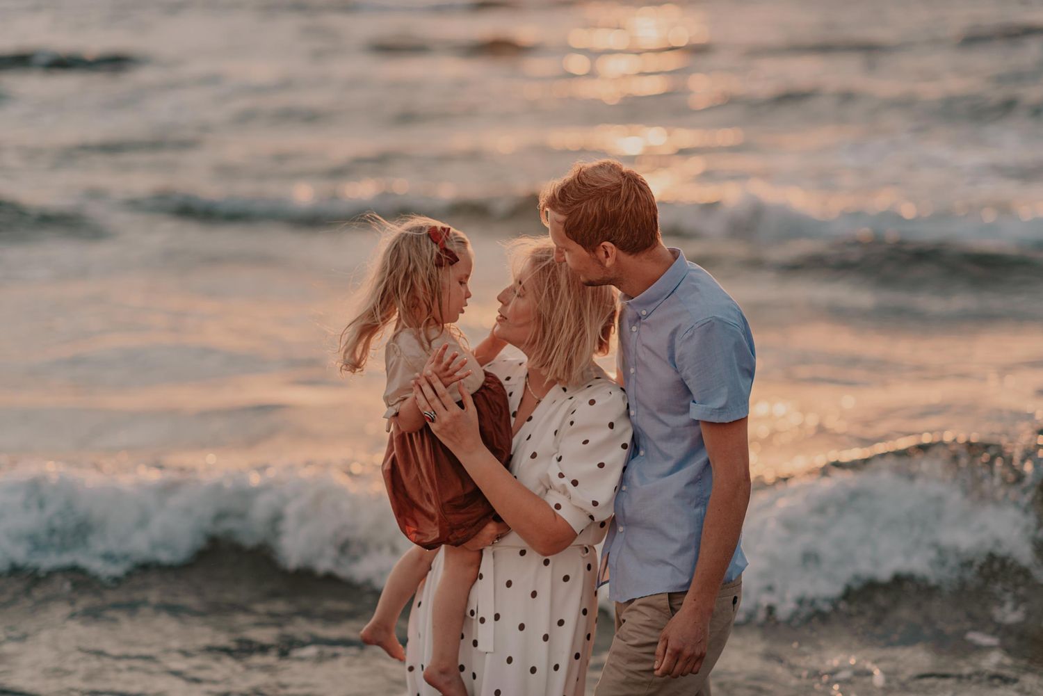 Intimate seaside moment captured during sunset with waves rolling onto shore.