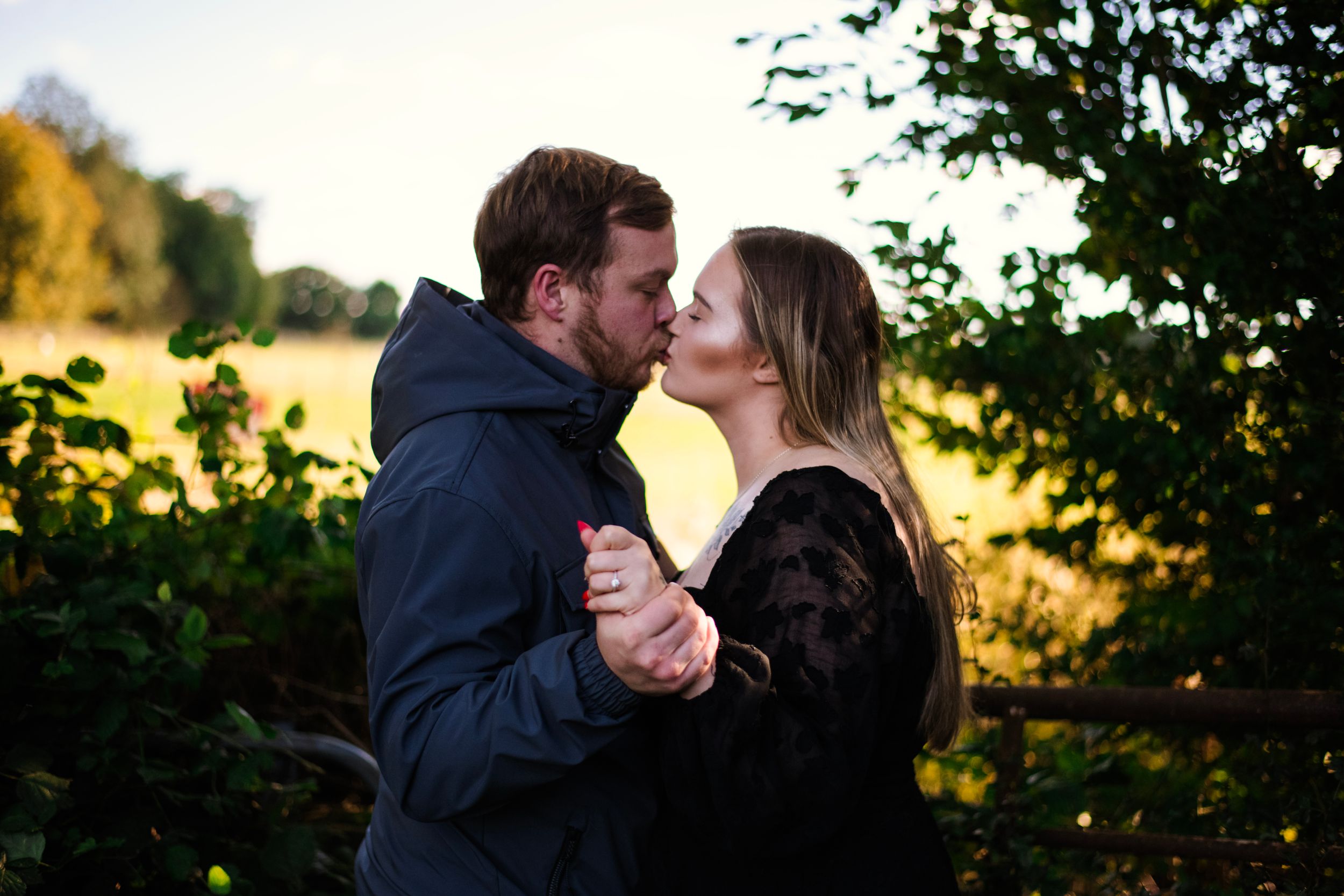 A romantic sunset moment between a couple in a natural outdoor setting.
