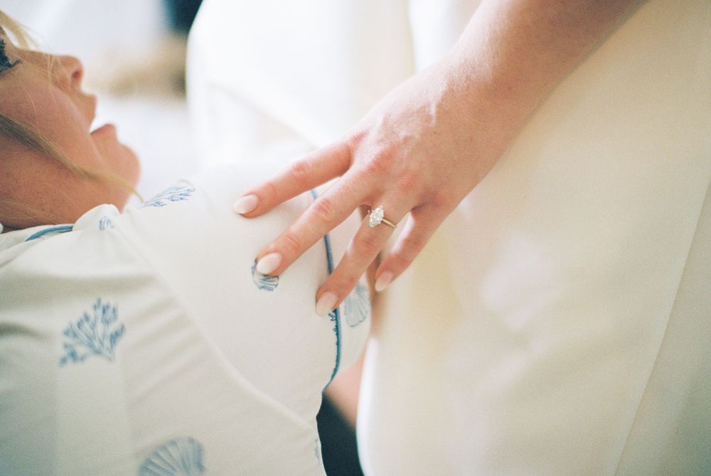 Close-up shots of hands gently folding white paper into delicate origami shapes on a light surface.