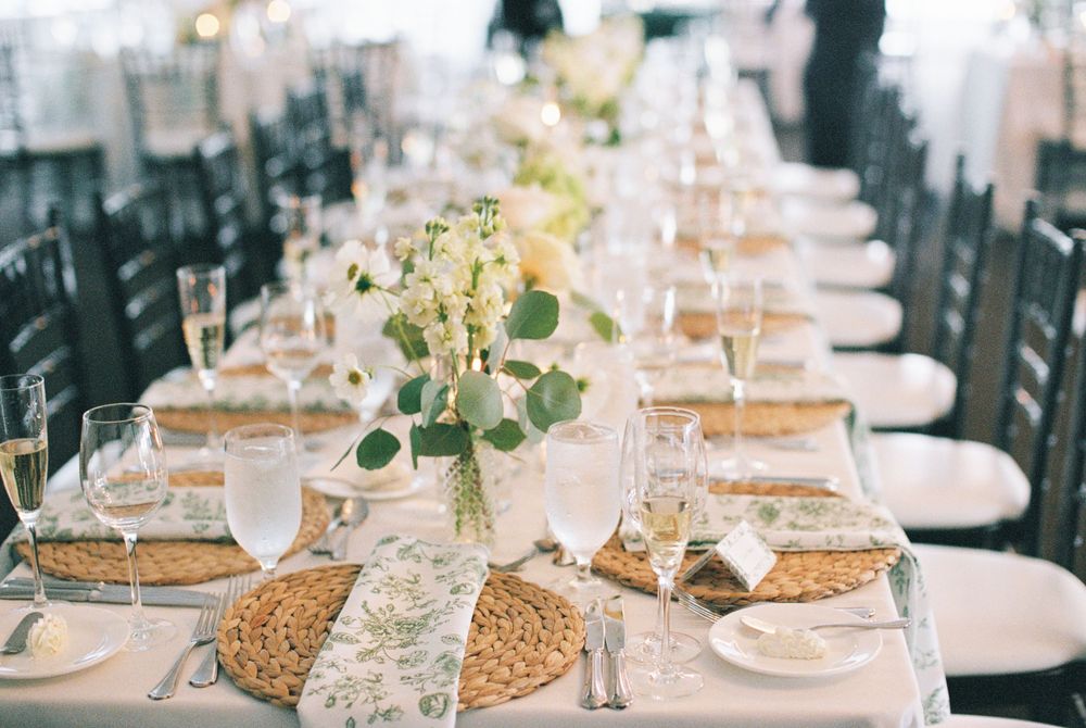 Long banquet table set with elegant place settings and floral centerpieces for a wedding reception.