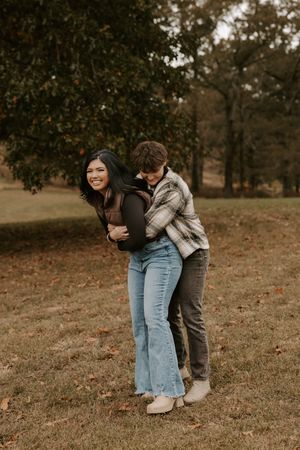 Candid moments of a couple hugging and laughing in a fall setting.