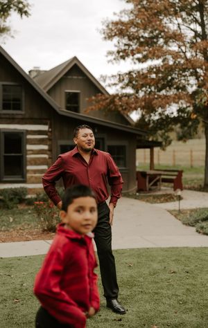 A sequence of outdoor photos showing a person in a red jacket playing and running on a grassy lawn near a building.