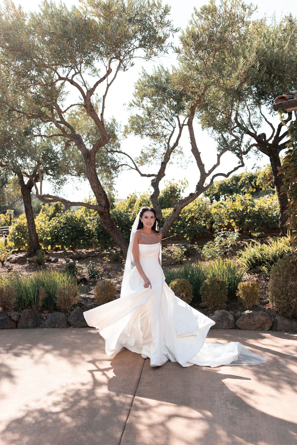 A flowing white wedding dress twirls gracefully in a series of photos against a Mediterranean garden backdrop.