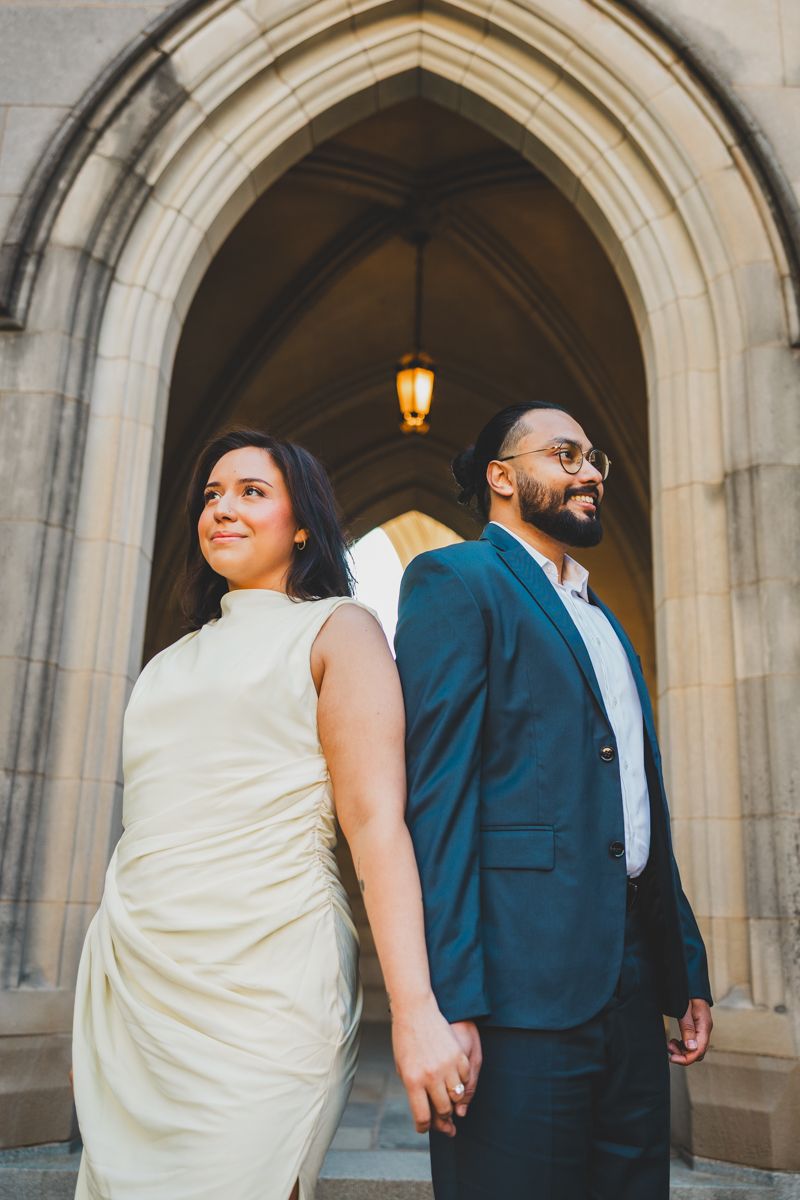 A couple in wedding attire share playful poses in a series of photos under stone archways with warm lighting at the bishop gardens
