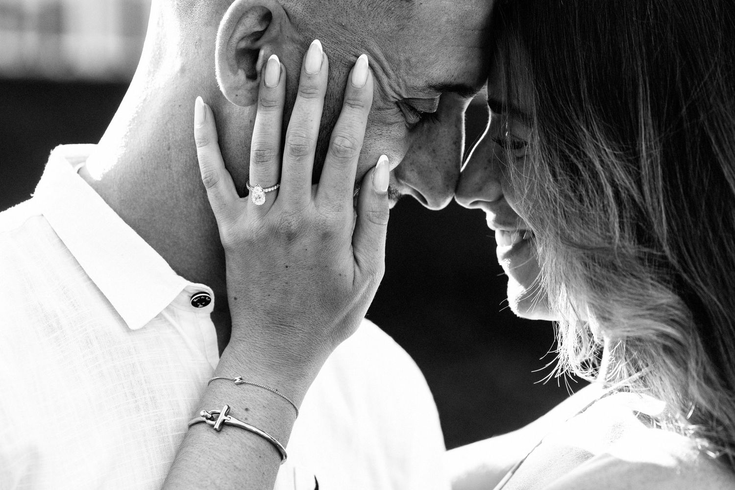 An intimate black and white portrait of a tender moment between two people.