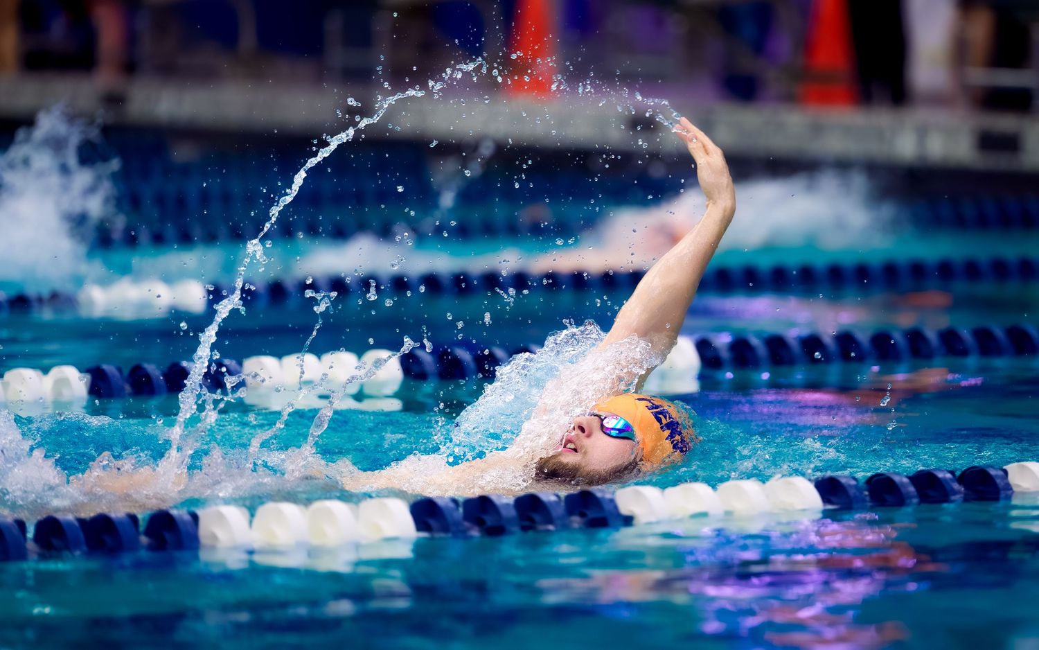Hershey High School Trojan Swimming races in orange swim caps by SportsFox Photography, Hershey PA