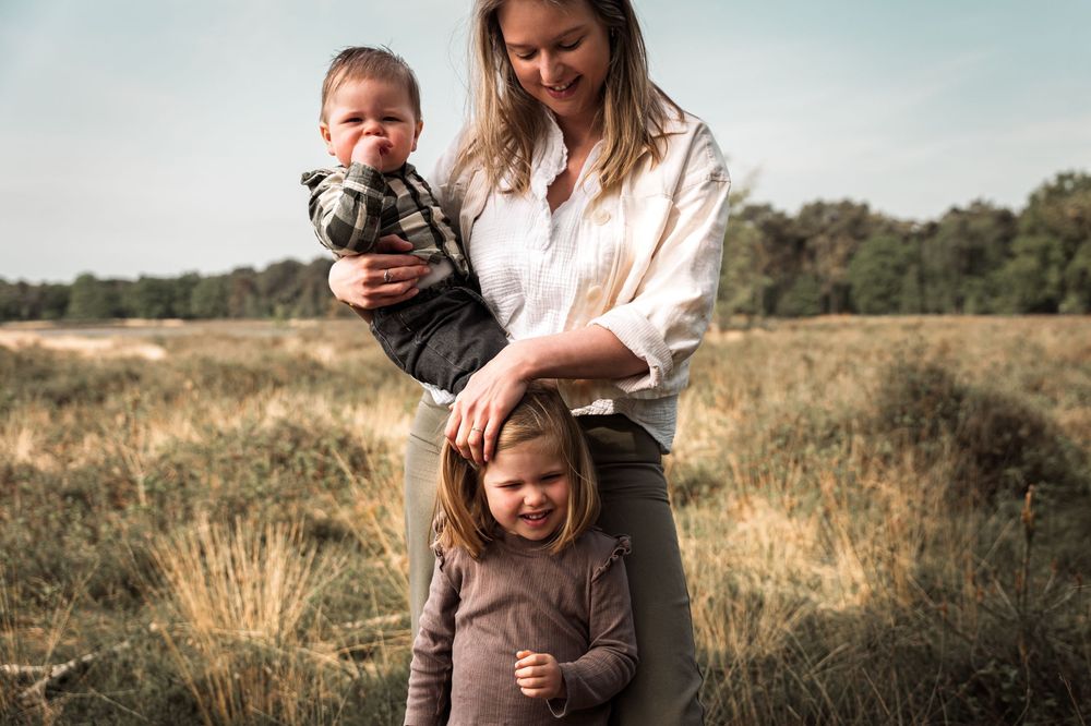 Family enjoying time together in a golden autumn field at sunset.