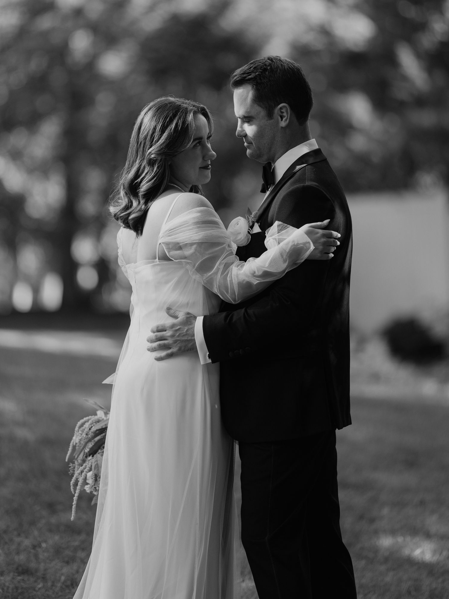Black and white photo of newlyweds embracing during their first dance.