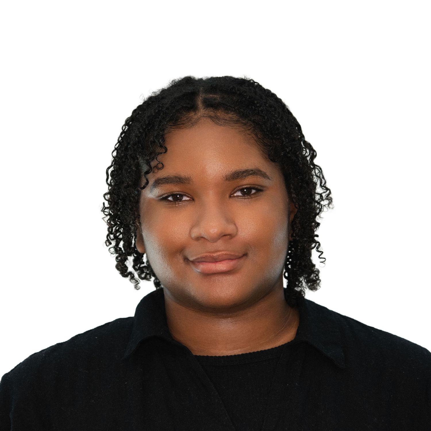 A young person with curly hair and a warm smile wearing a black top in Professional Headshots in Boston, MA with Leah Ramuglia Photography.