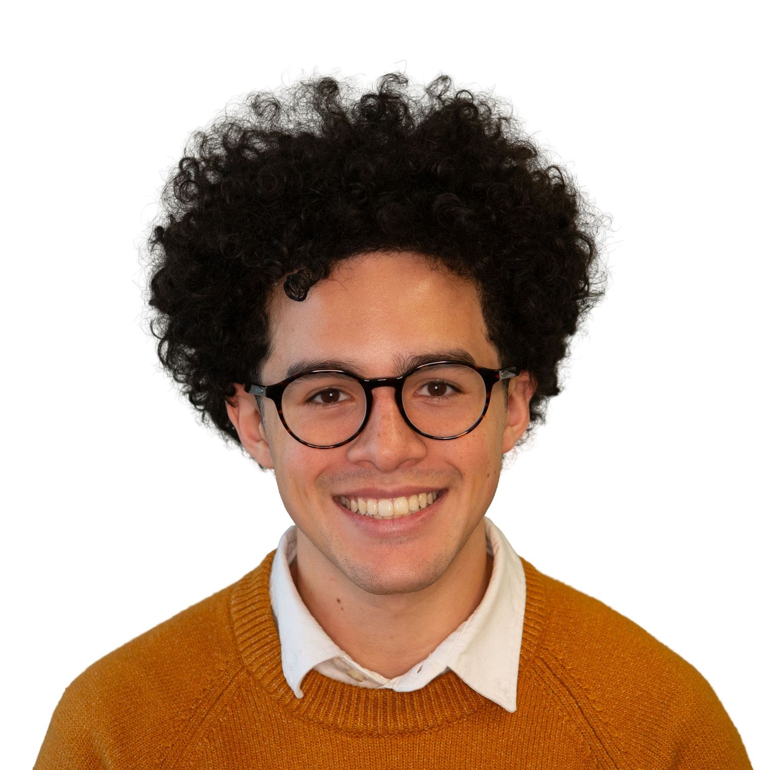 Person with curly dark hair and glasses wearing an orange sweater smiles in professional headshots with Leah Ramuglia Photography.