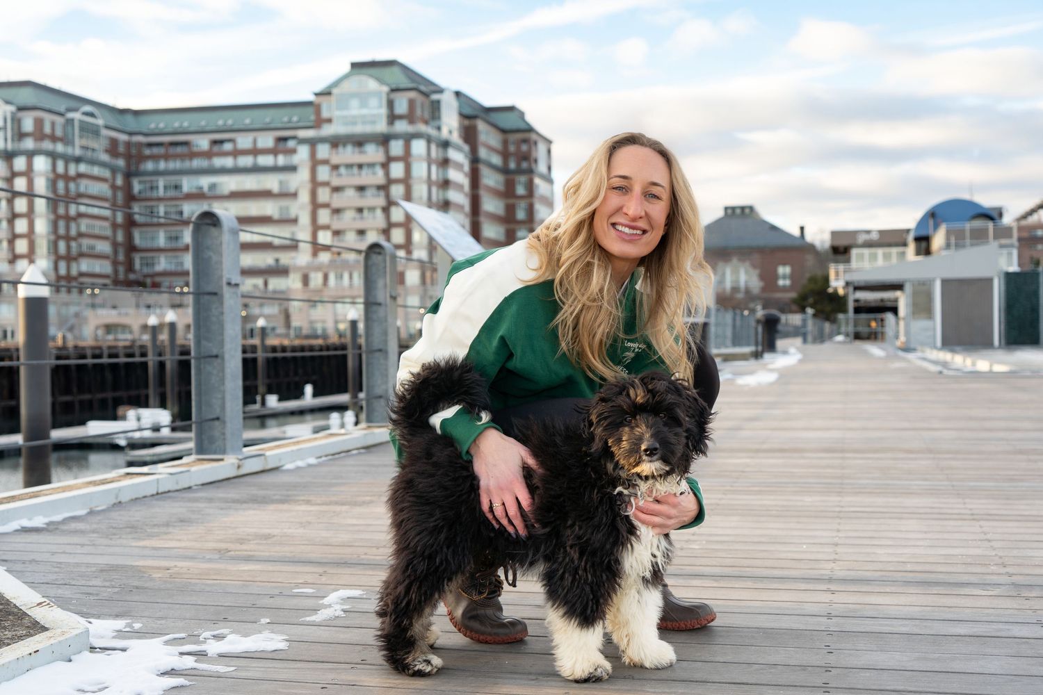 A woman & her Irish Water Spaniel Puppy and his Human, photographed in Boston, MA by Leah Ramuglia Photography in the Charlestown Navy Yard.