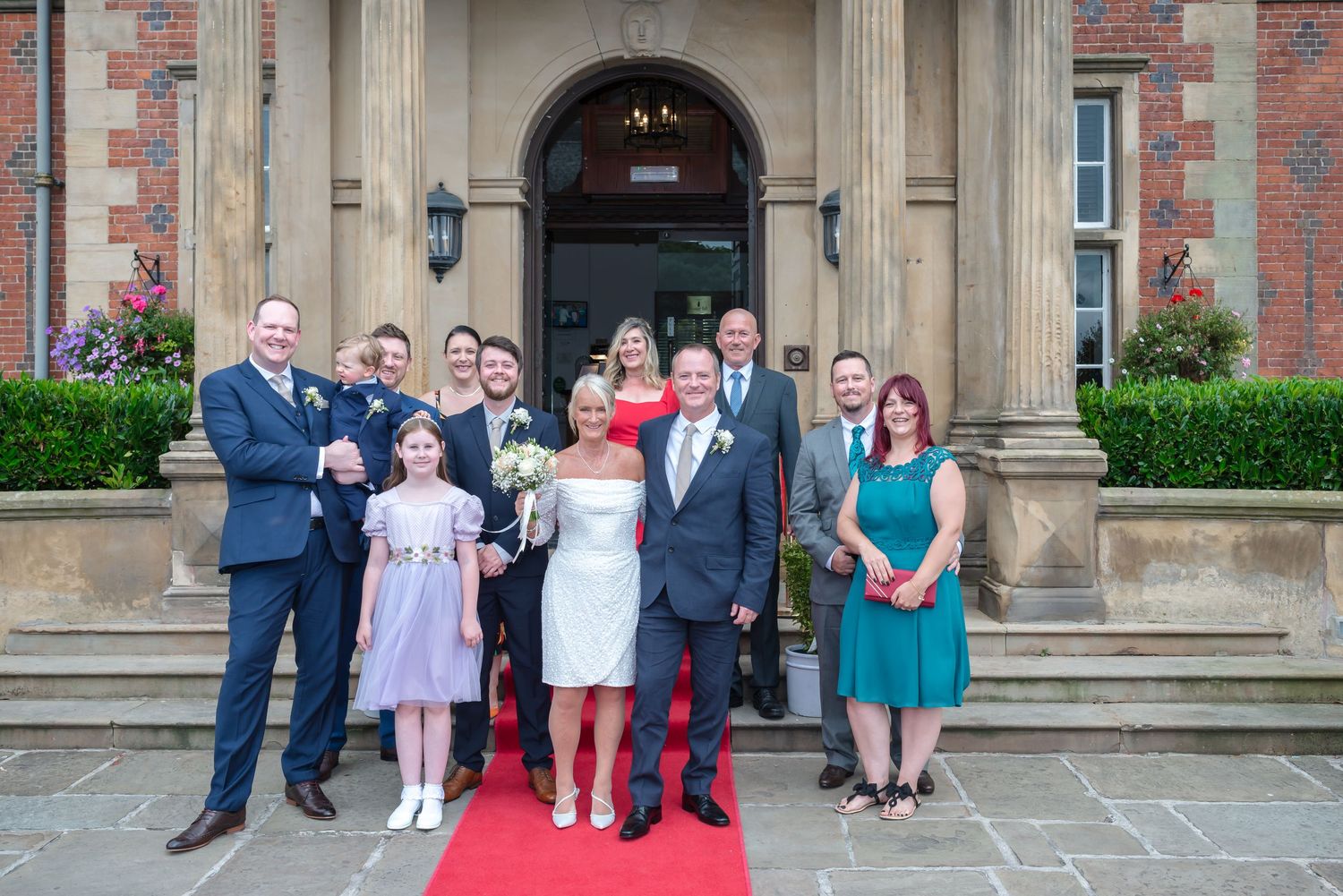 A series of wedding photos showing groups gathered outside a stone building entrance with red brick walls.