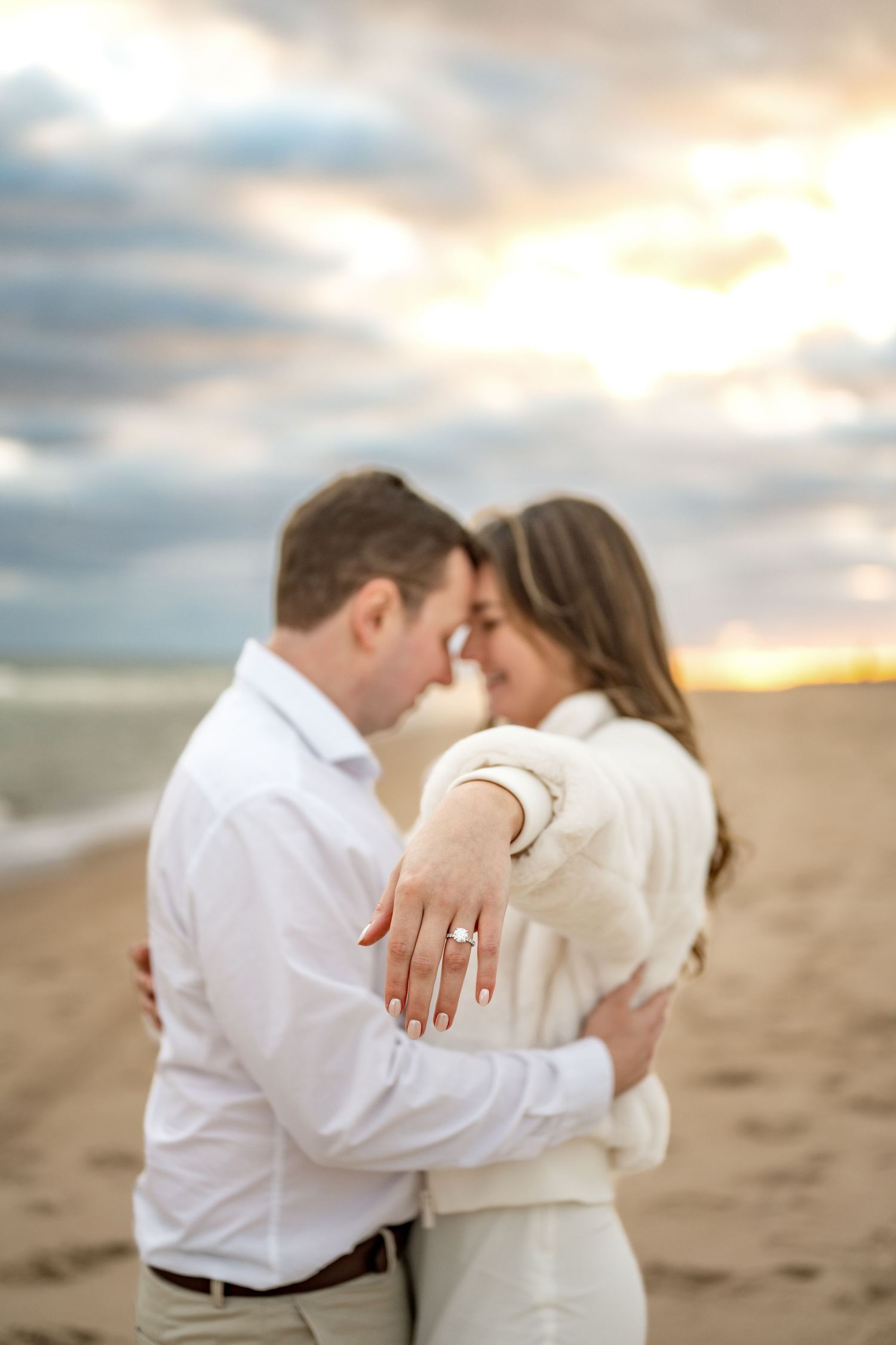 A romantic proposal scene set between rows of grapevines in a scenic vineyard with white flowers and a blanket.