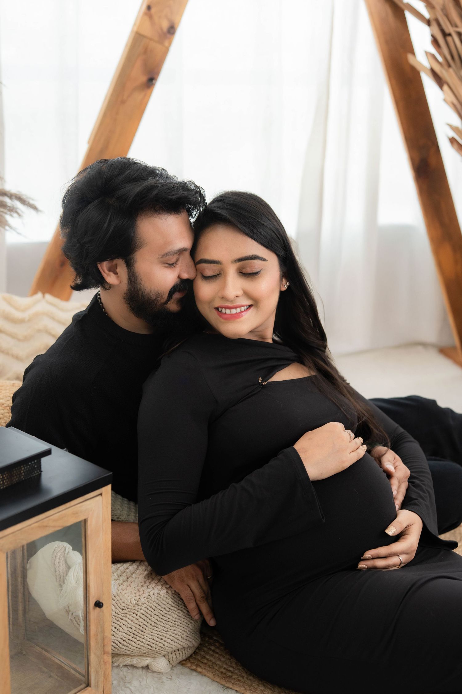Couple sharing emotional bonding during studio maternity photoshoot, expecting parents in Hyderabad