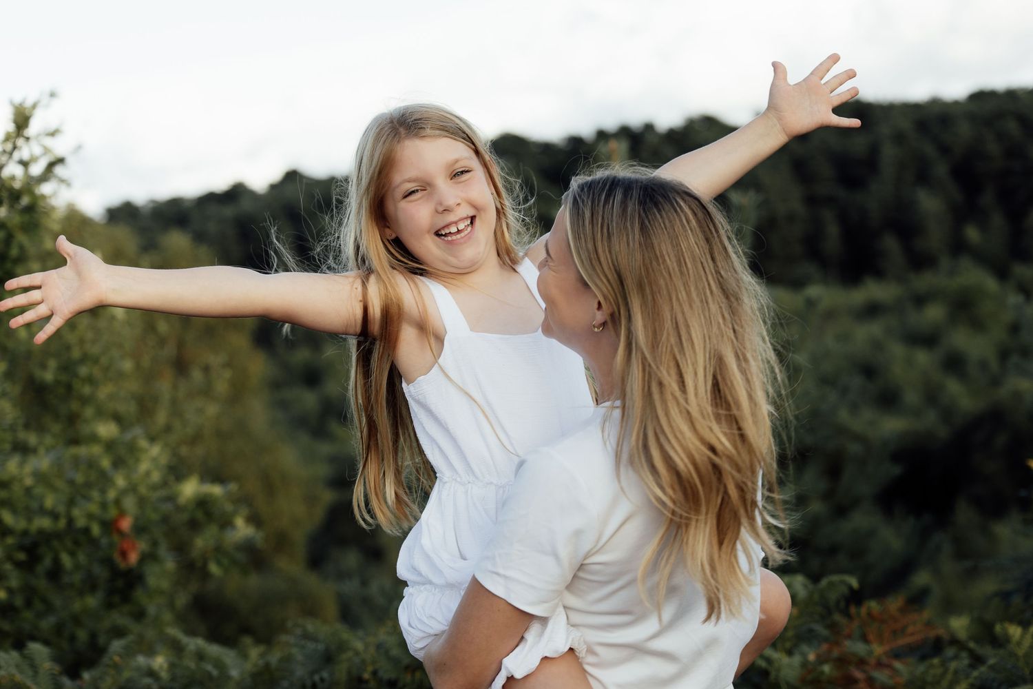 Natural mummy and me moment.  Mum holding her young daughter, spinning her round to make her laugh.