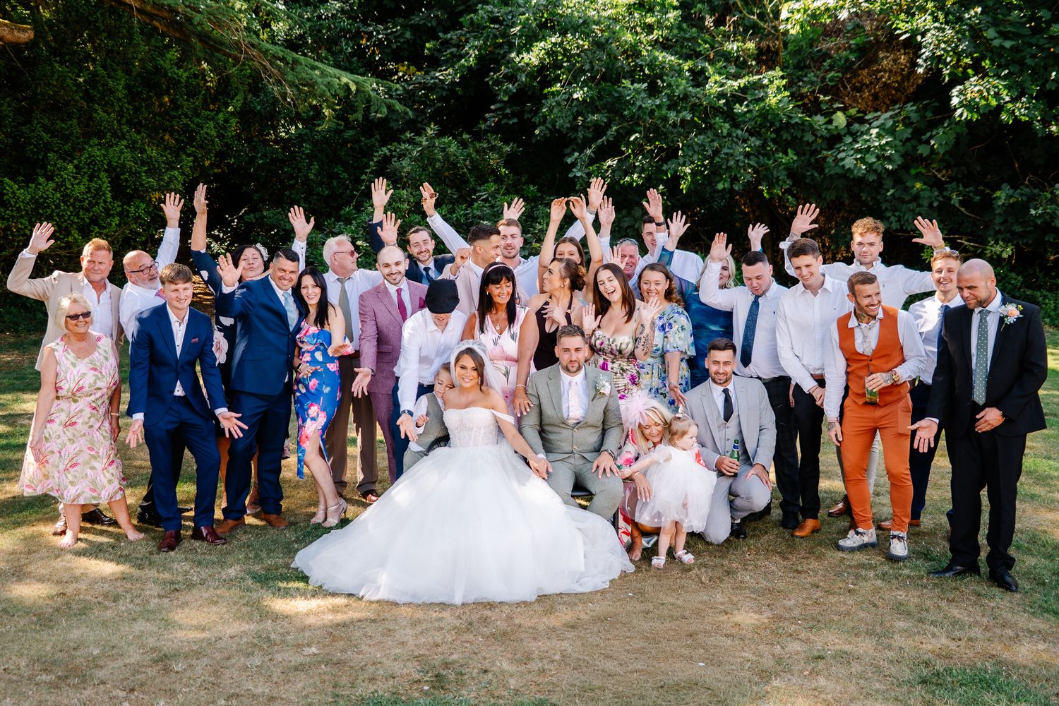 Couple at Orange Grove wedding venue playing photo roulette together with full wedding party posing for a fun group photo