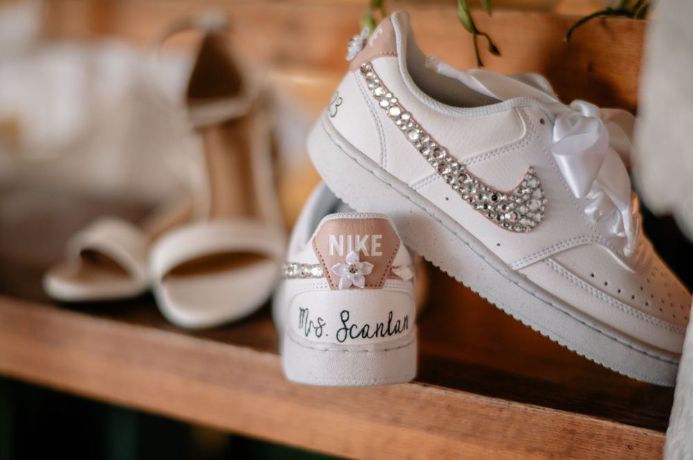 Customized white Nike sneakers with crystal details displayed as wedding shoes.