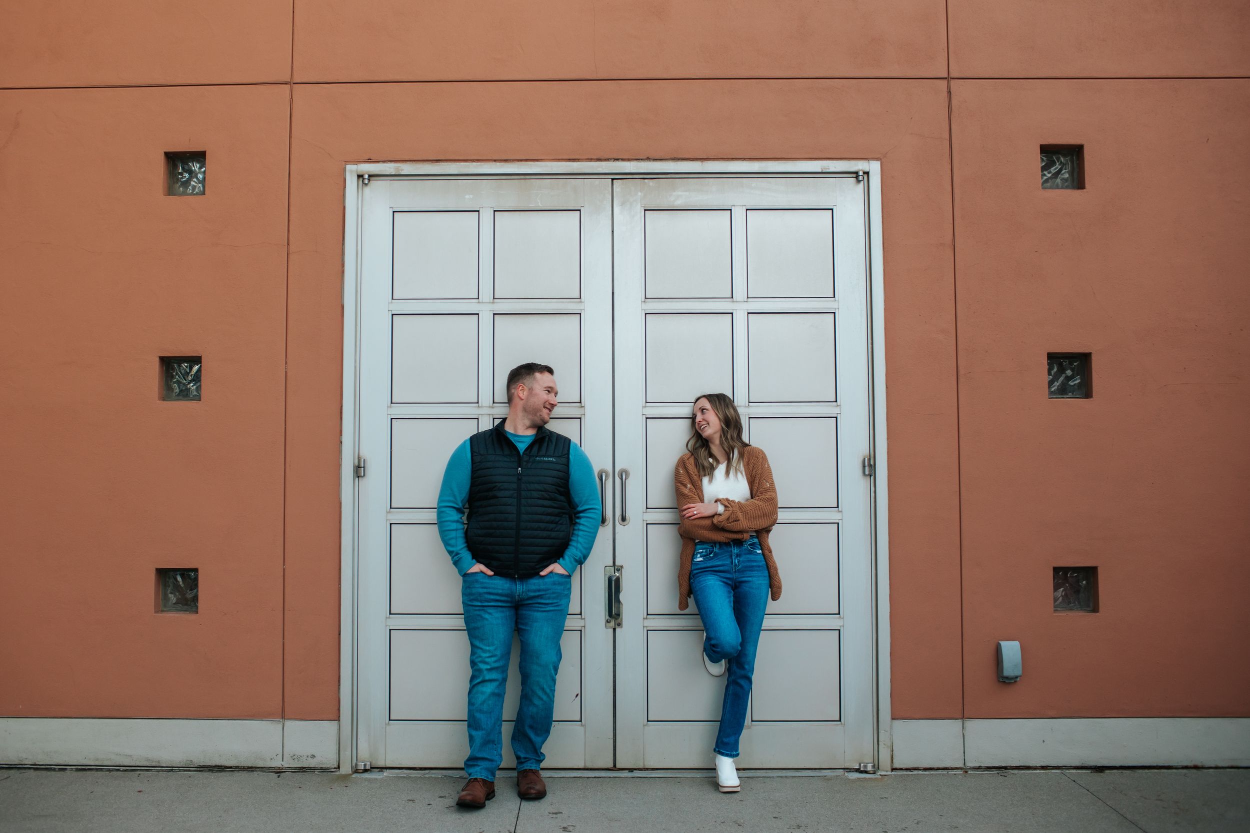 Modern architectural backdrop frames couple's casual photoshoot.