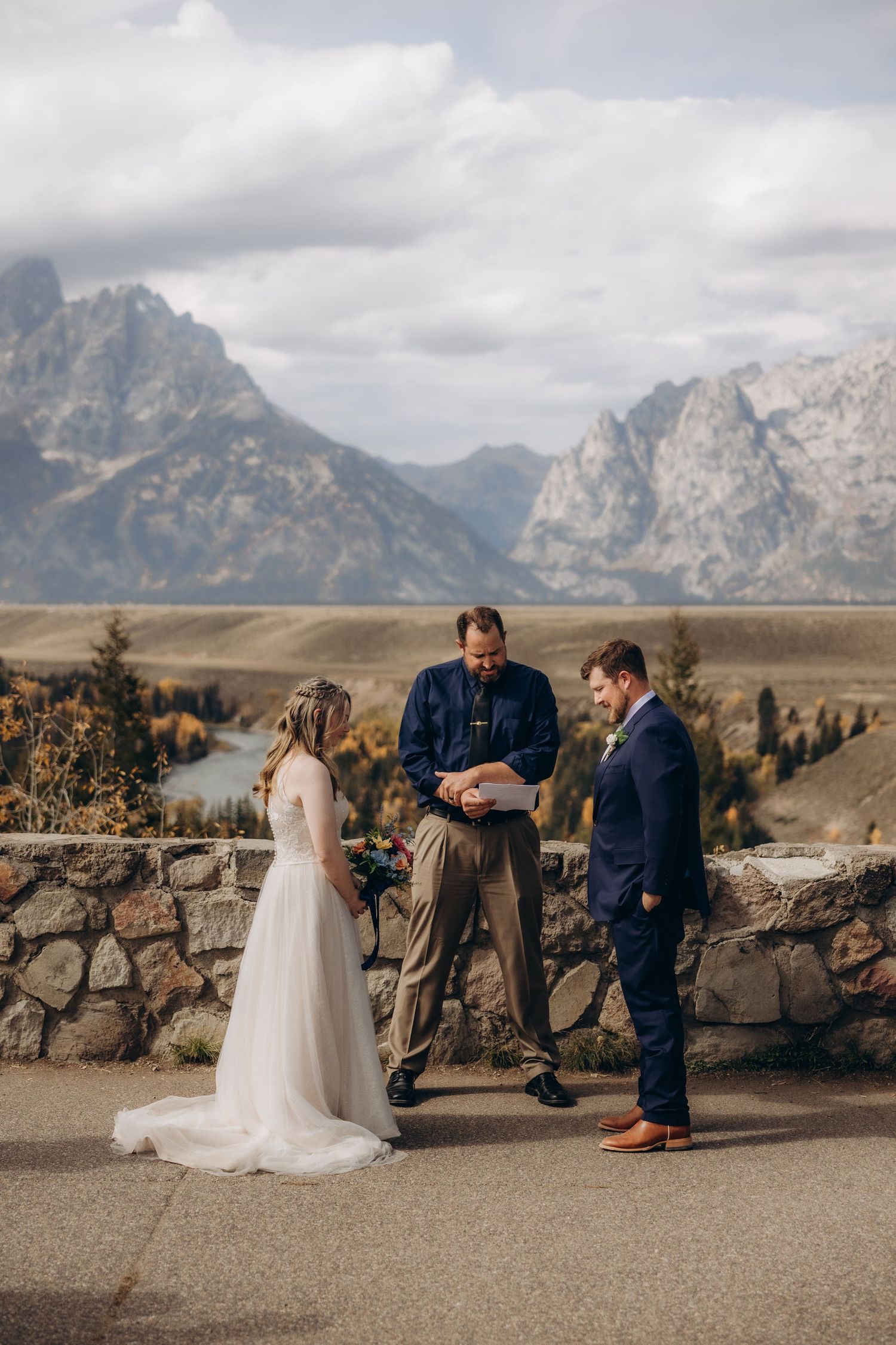 A wedding ceremony takes place against a dramatic mountain backdrop at Grand Teton National Park.