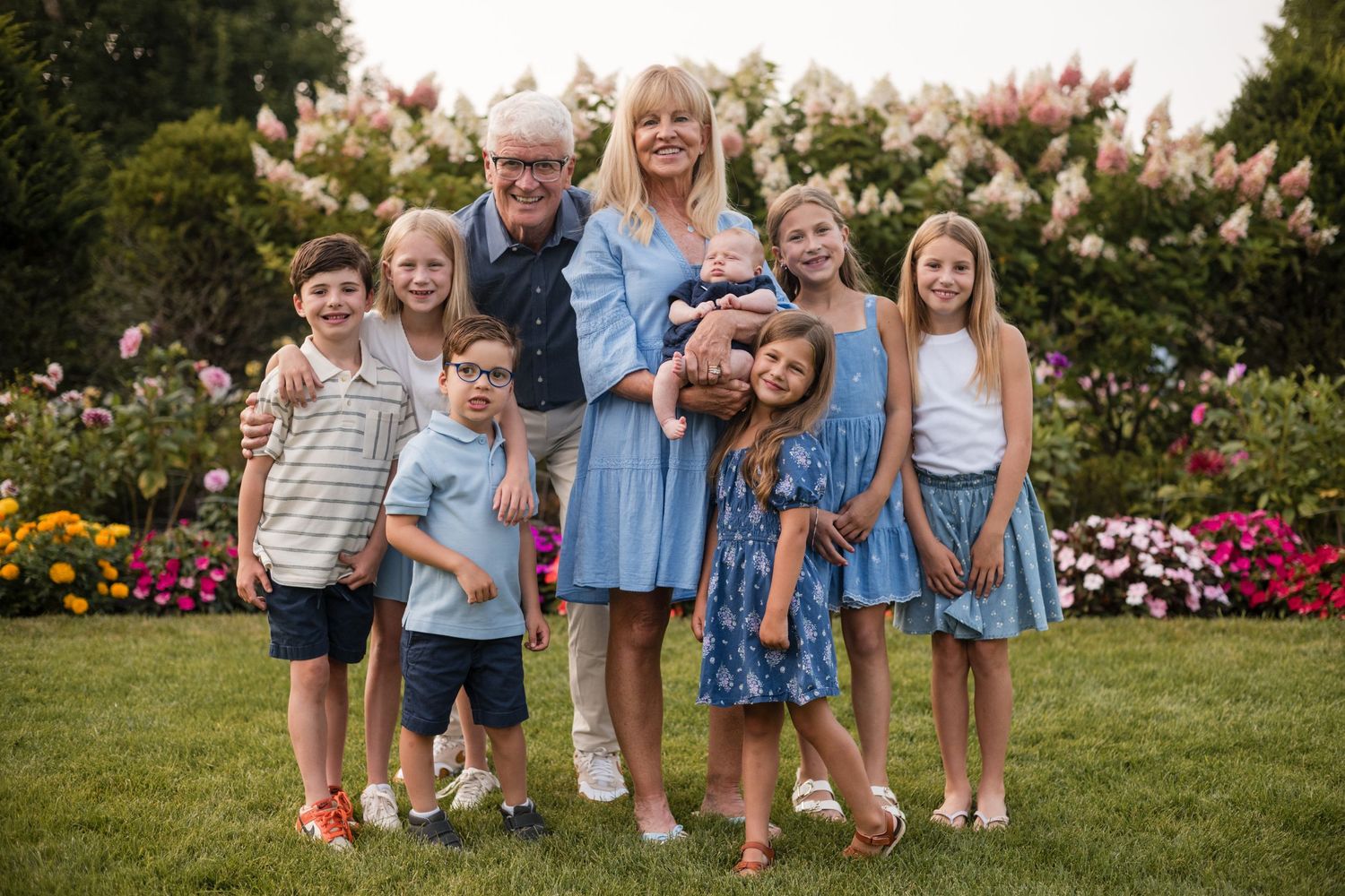 A series of outdoor family portrait photos showing joyful moments in a garden setting with blooming flowers and greenery.
