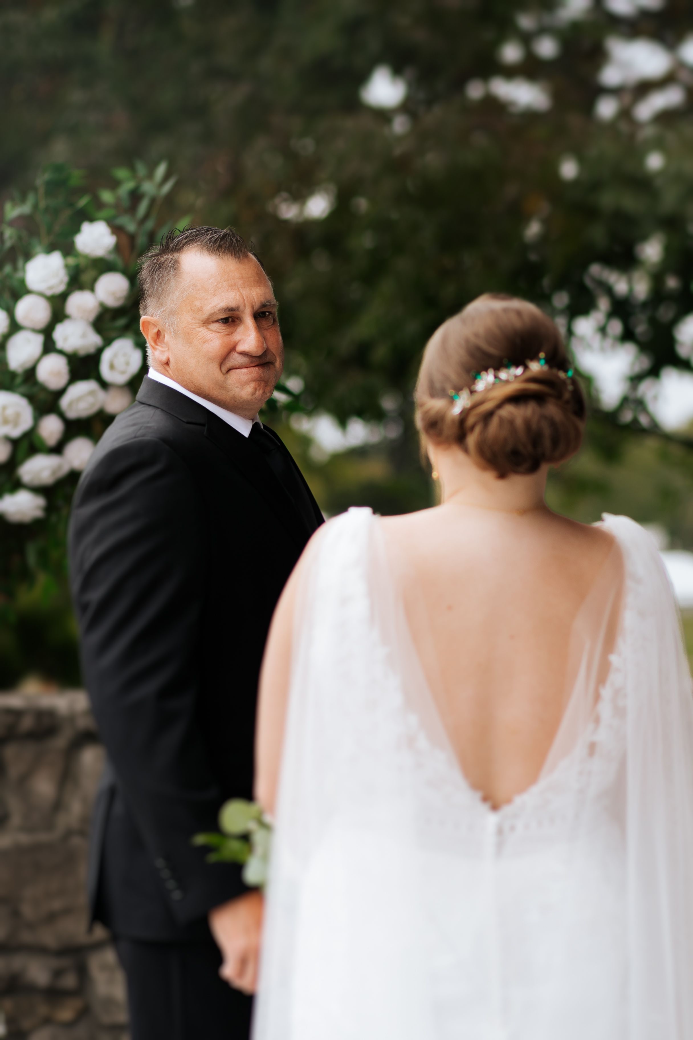 First look moment with a bride and her father outdoors with white flowers in the background. Conner Prairie, Fishers Indiana