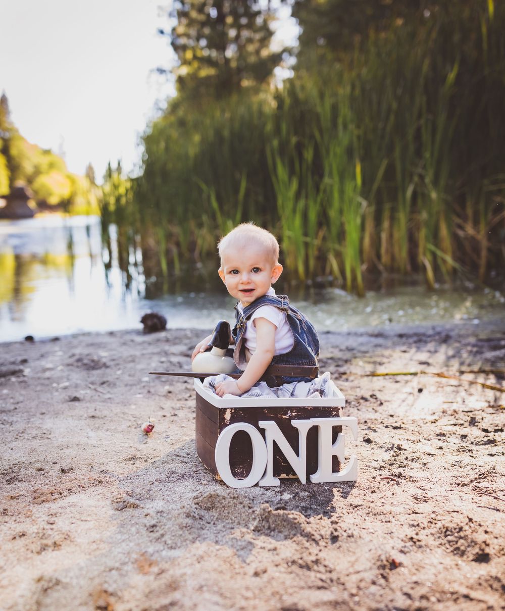 A peaceful sandy beach setting with decorative wooden letters and natural greenery in the background.