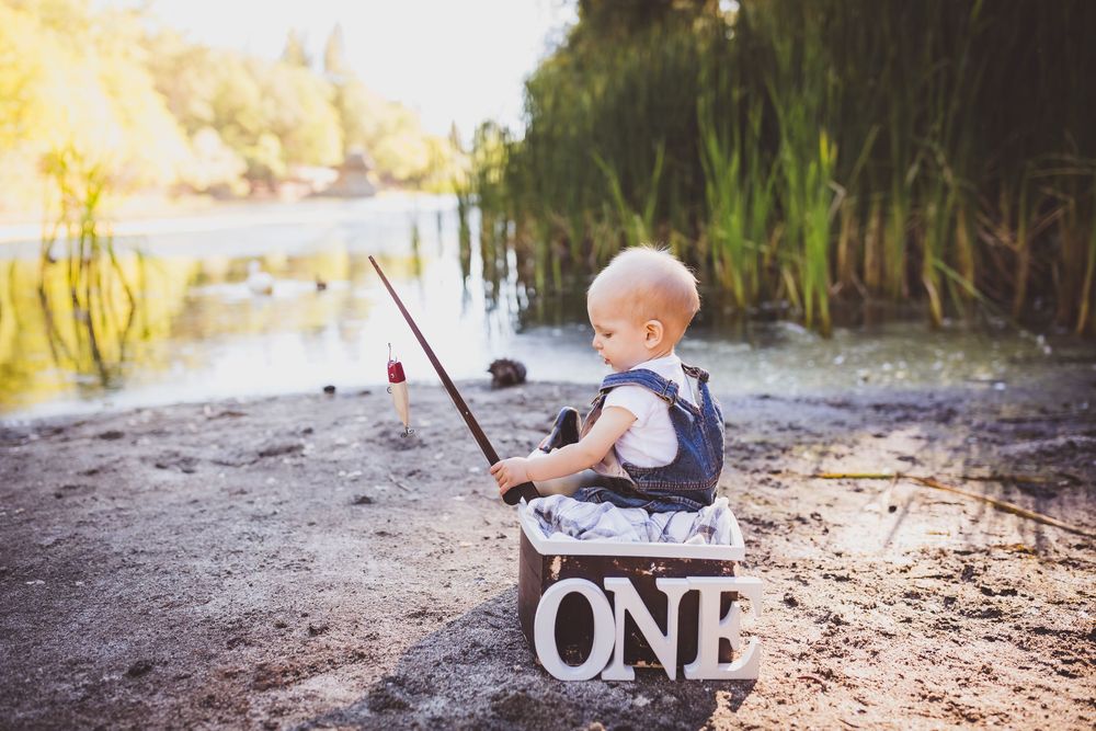 A wooden wagon and decorative blocks are arranged on a shoreline with natural sunlit scenery.