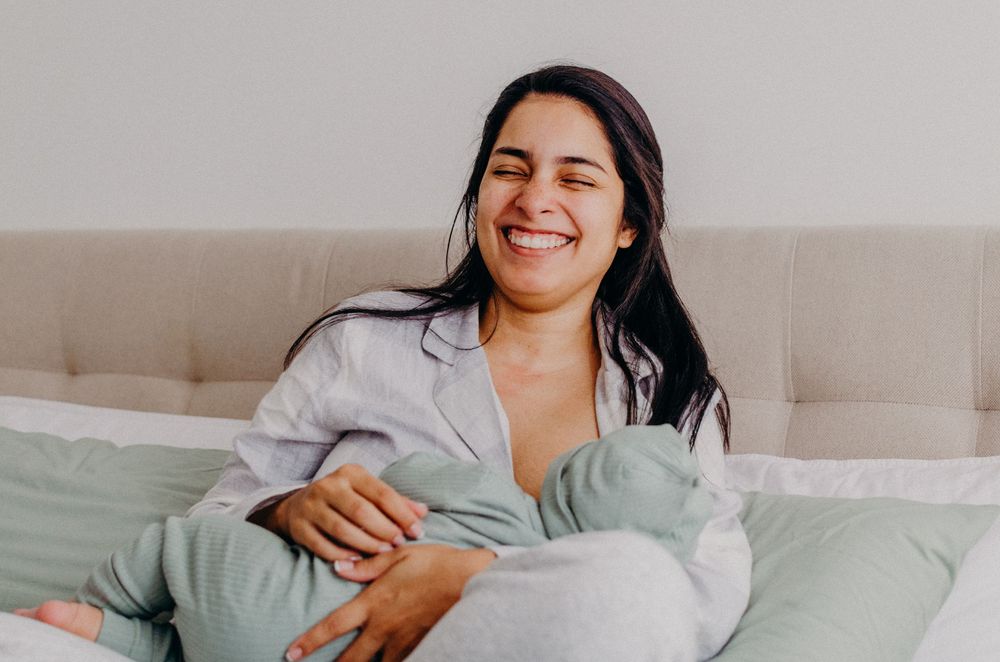 Someone lounging comfortably on a bed with soft lighting and neutral decor.