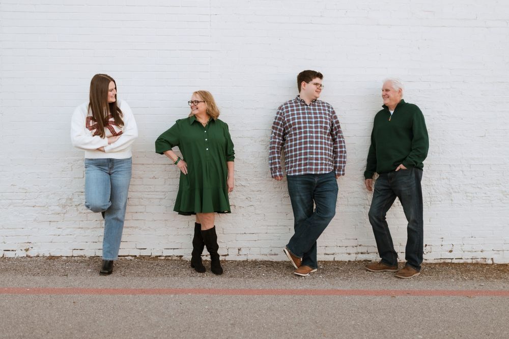 Family wearing coordinated green and casual outfits posing against white wall in sequence of candid shots.