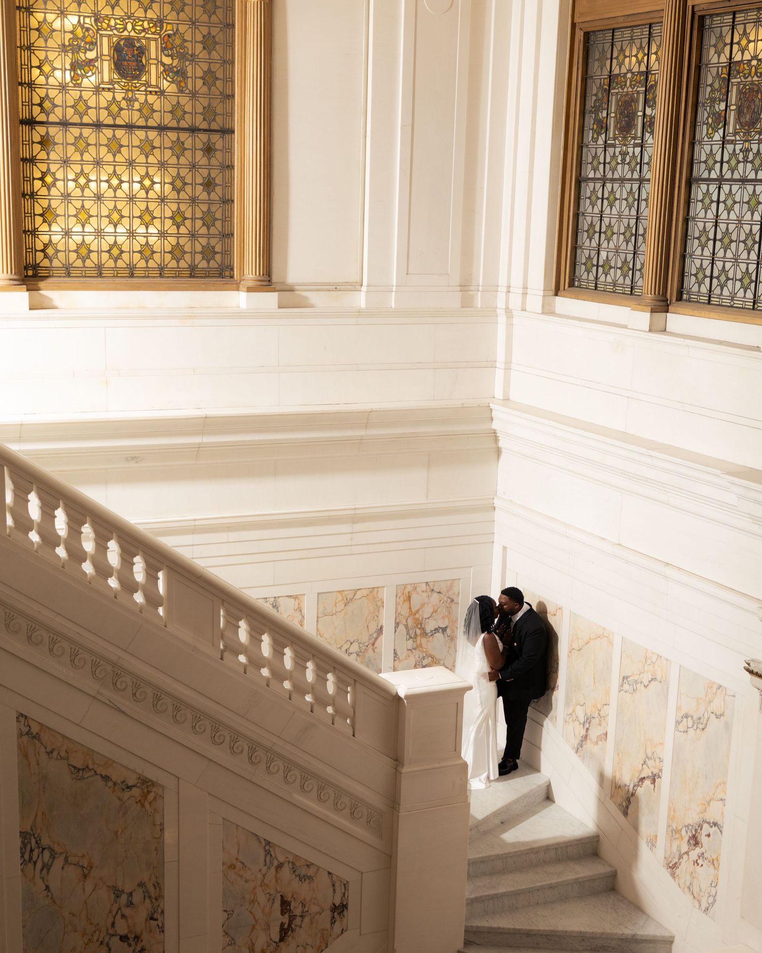 Elegant wedding photoshoot with white staircase interior with ornate architectural details and lighting at the Kimpton Hotel Baltimore