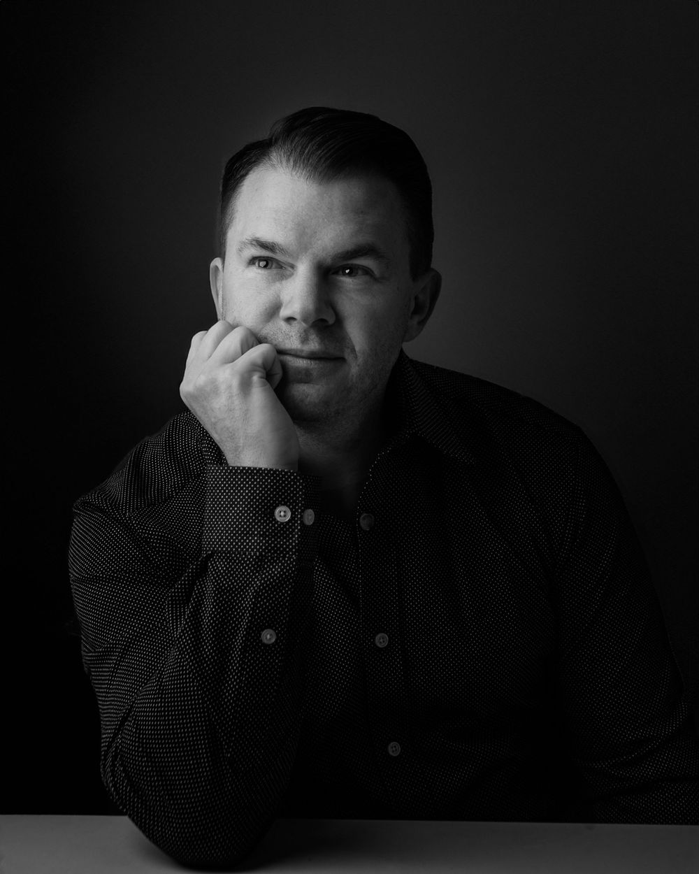 Four dramatic black and white portraits showing expressive emotions in moody lighting against dark backgrounds.