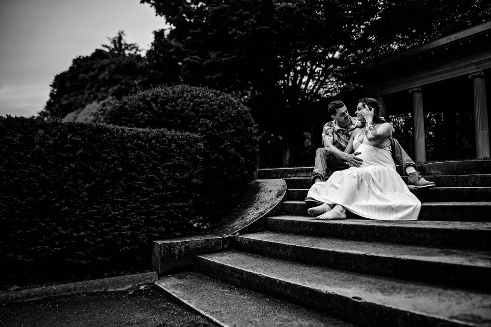 A series of black and white wedding photos showing romantic moments between a couple in outdoor settings.