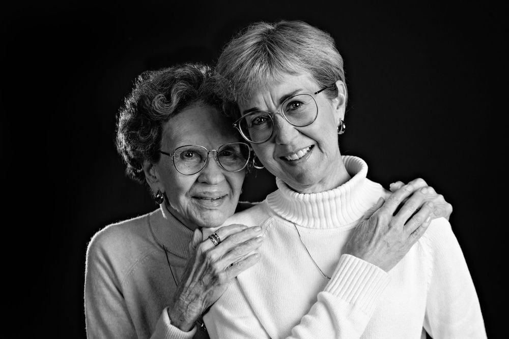 Black and white photo series showing affectionate moments between two people embracing and smiling together.