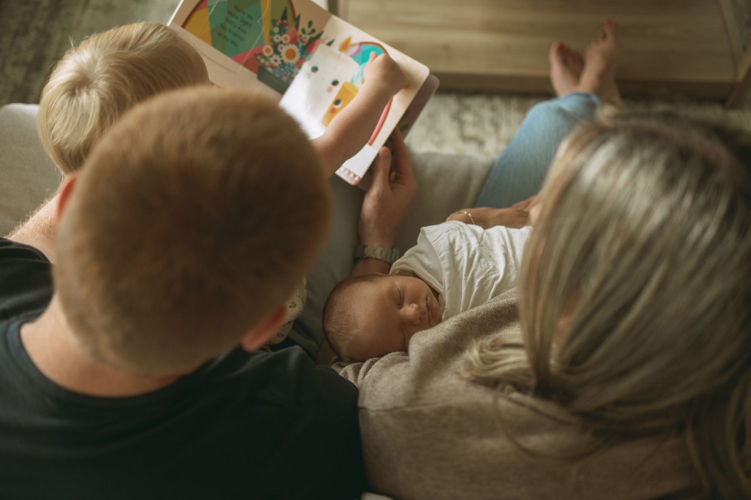 Couple sitting by nursery crib holding newborn in cozy home setting.