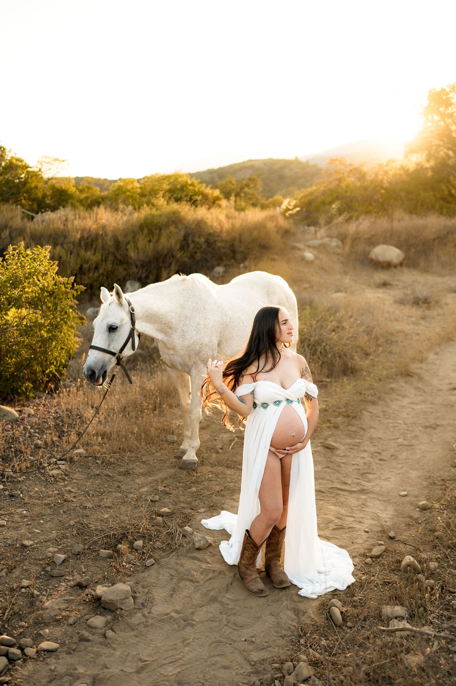 Ojai horse maternity photoshoot in golden grassy field with woman in sheer open belly dress and by Ventura maternity photographer