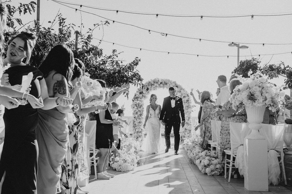 Wedding guests dance and celebrate under strung lights at an outdoor reception venue during a festive evening celebration.