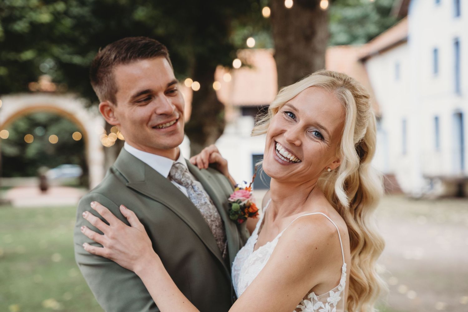 A joyful wedding moment captured in black and white outside a rustic barn with a vintage car in the background. Engelmannsbäke Visbek