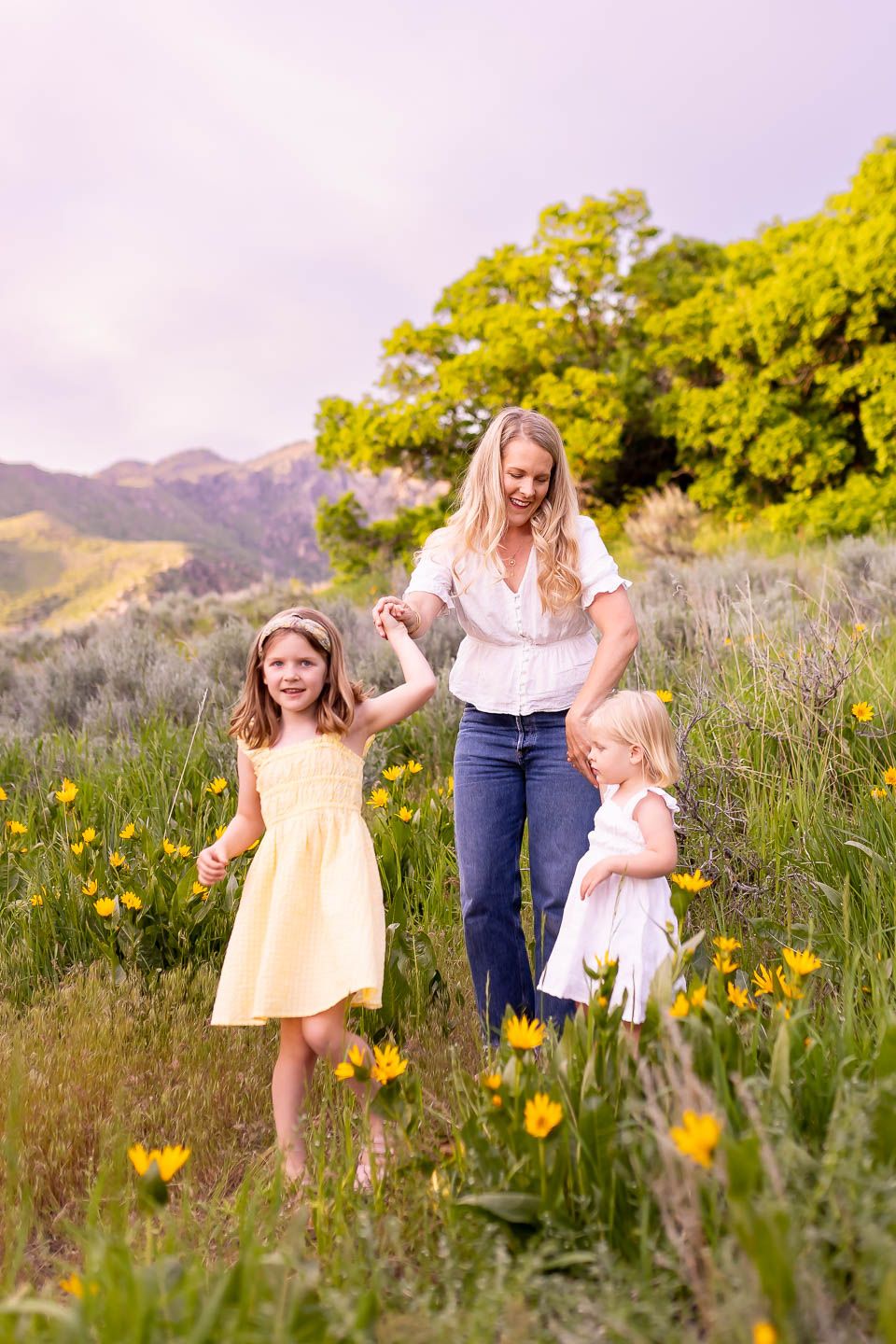 salt lake city utah family photographer, candid photo of a mom with two young daughters in a flower field
