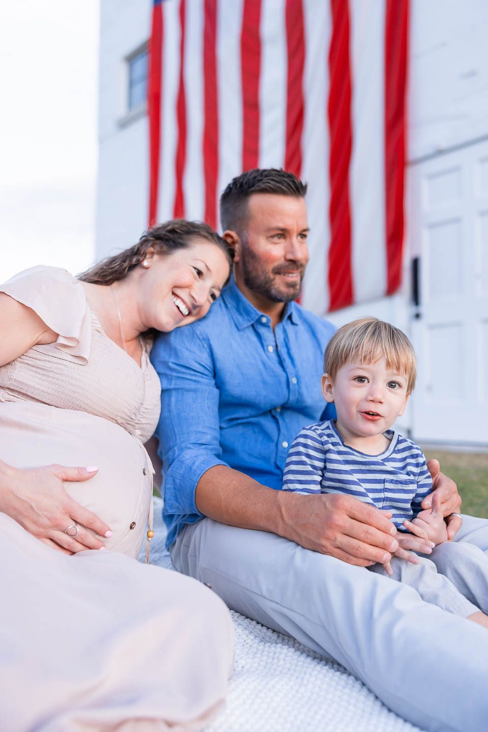 Park City utah maternity family photographer, candid photo of an expecting family having a messy snuggle at McPolin Farm american flag