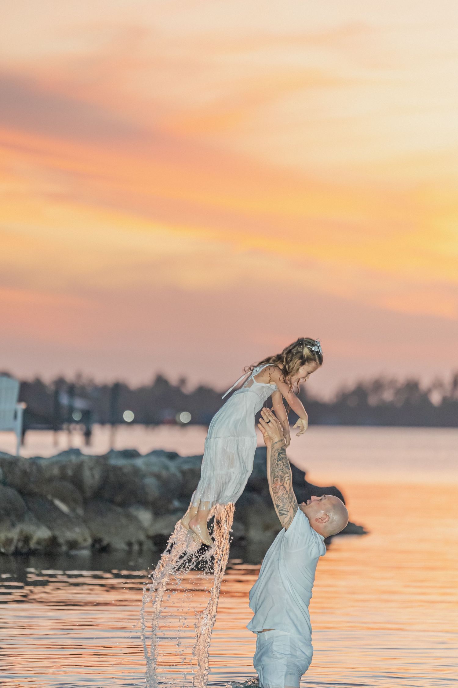 Beach wedding scene at twilight with palm trees silhouetted against the darkening sky.