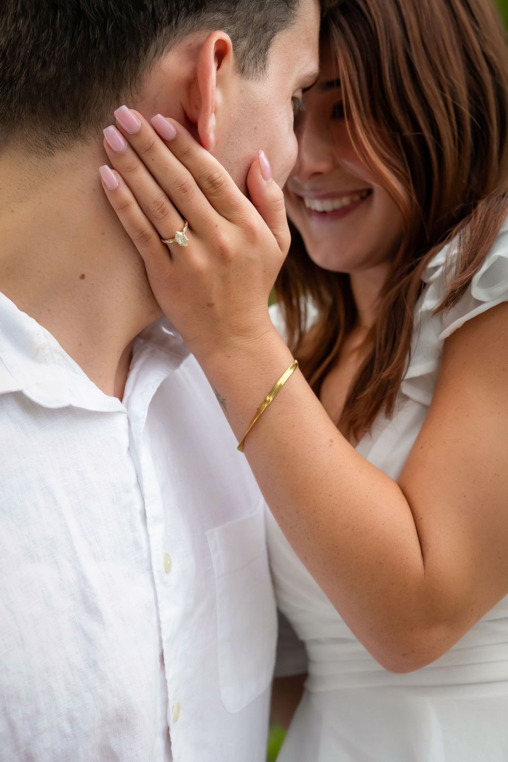 woman hand on man cheek showing off diamond ring