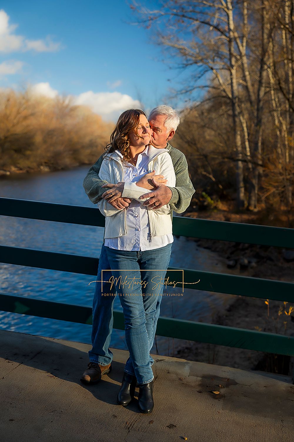Engaged older couple on bridge over river