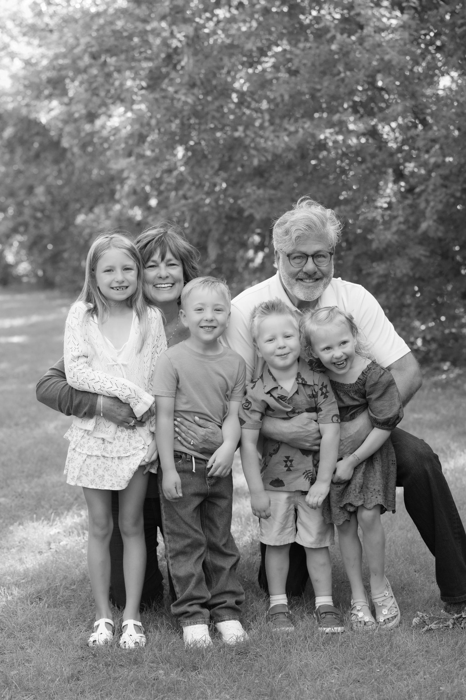 Grandparents squeeze their grandkids for a big group hug during an extended family session at Powers Lake Park in Woodbury, MN.
