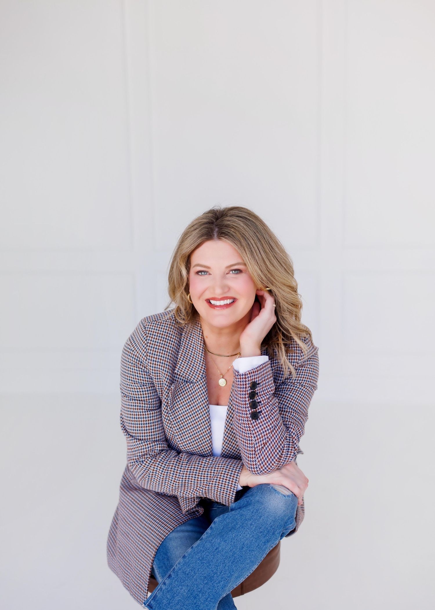 Person in blue cable knit sweater sitting against white background.