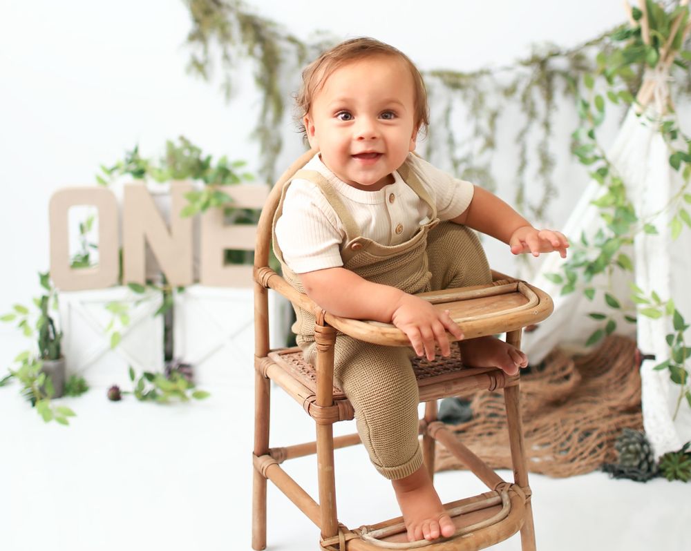 Baby boy in antique highchair for cake smash session