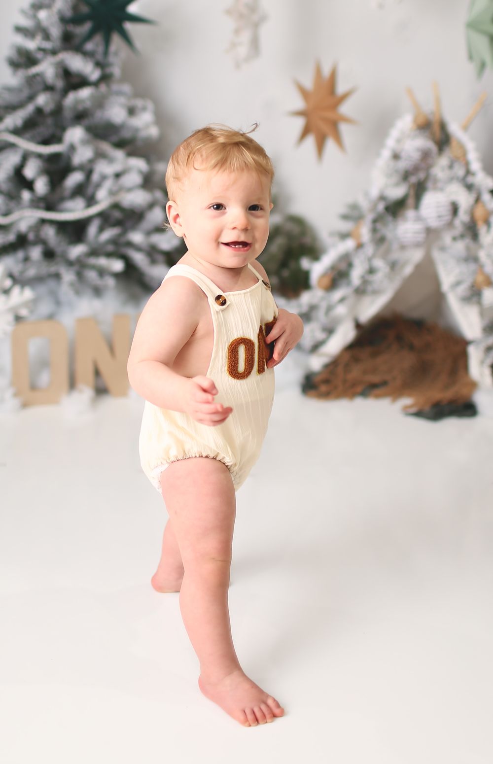 First birthday session with baby boy standing smiling