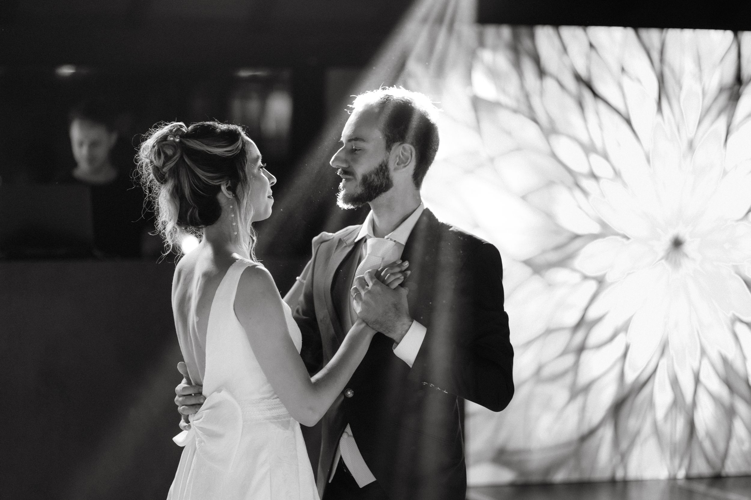 A romantic dance moment captured in black and white with a glowing backdrop.