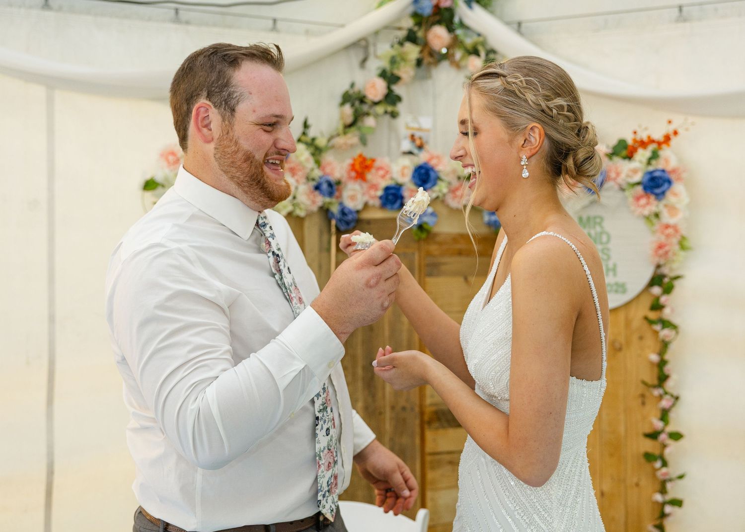 married couple eating wedding cake at their wedding reception