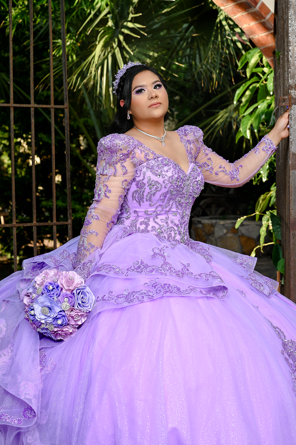 Detailed shot of ornate purple quinceanera gown with matching floral bouquet.